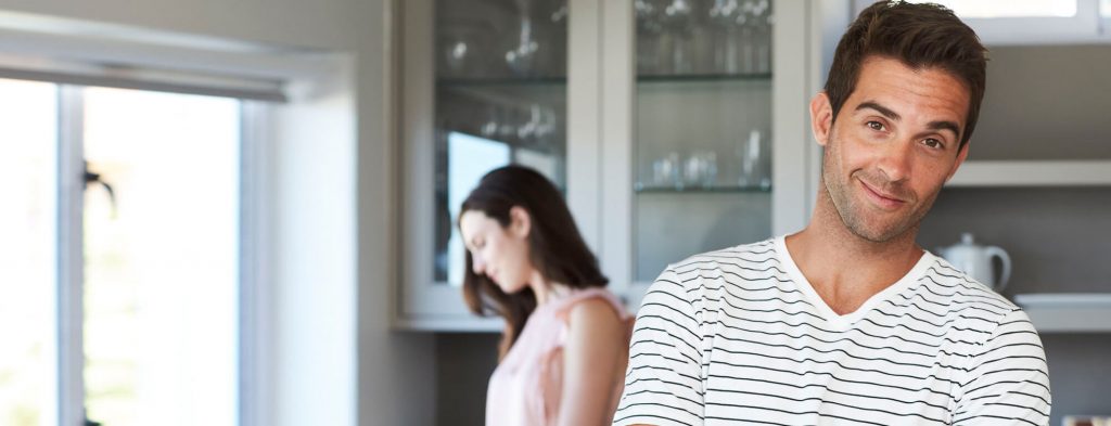 Guy smiling girl cooking in back